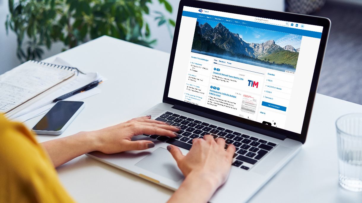Person schreibt auf Laptop. Zu sehen ist das AMS Intranet