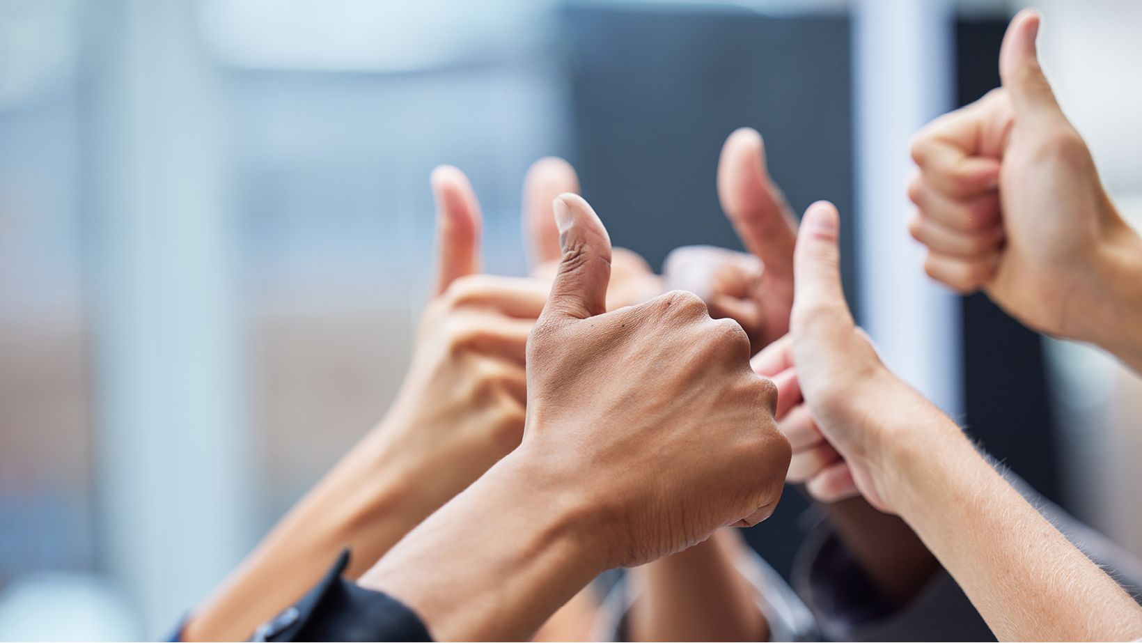 Daumen hoch, @iStock.com/PeopleImages Viele Leute strecken ihren Daumen hoch